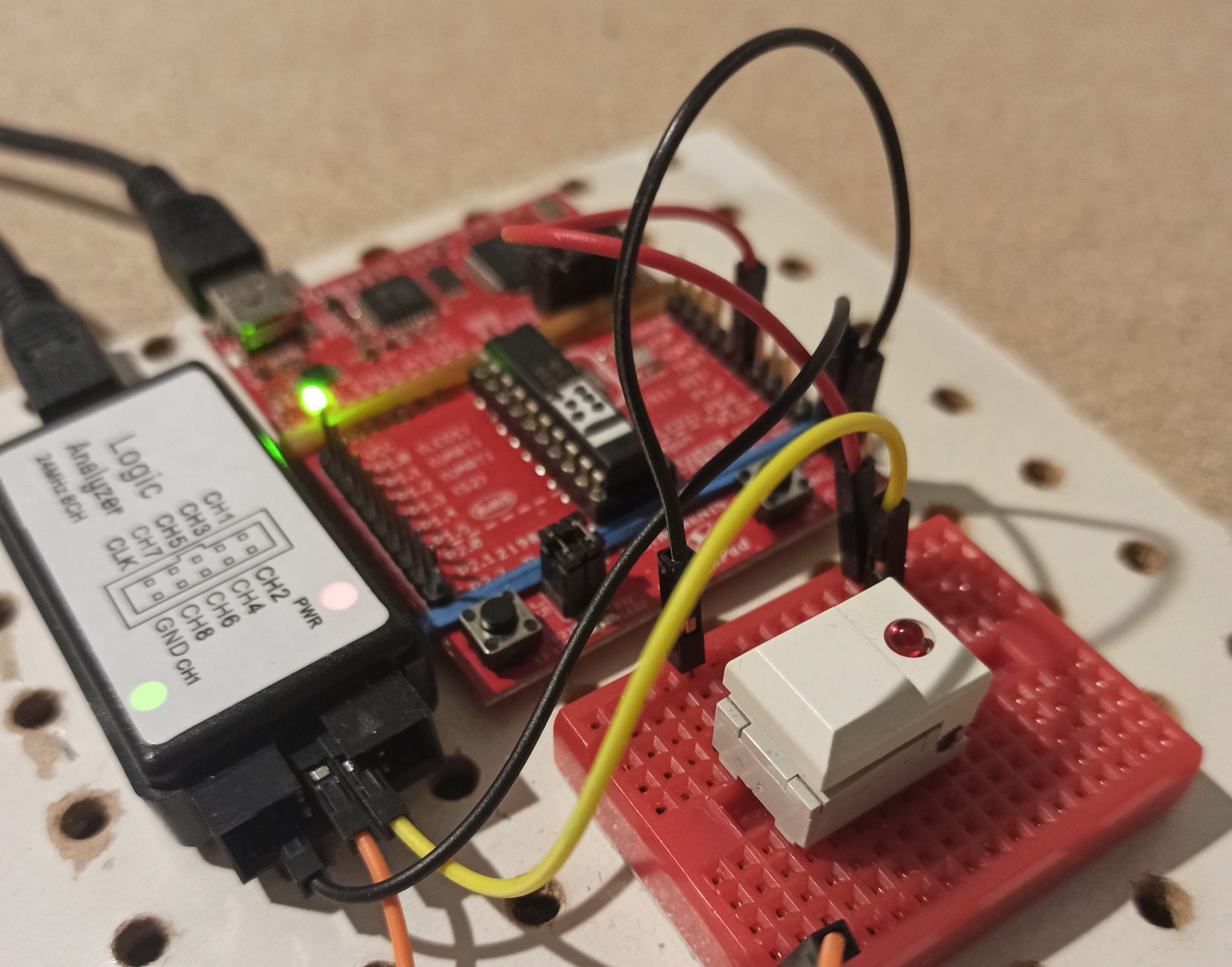 The small white button is on the breadboard at the bottom right of the picture.